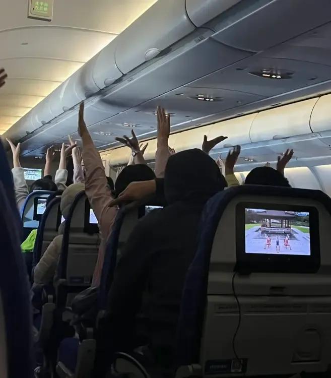 飞机上一睁开眼，发现乘客都举着双手，吓了一跳！以为发生了什么事儿？原来是空姐带着