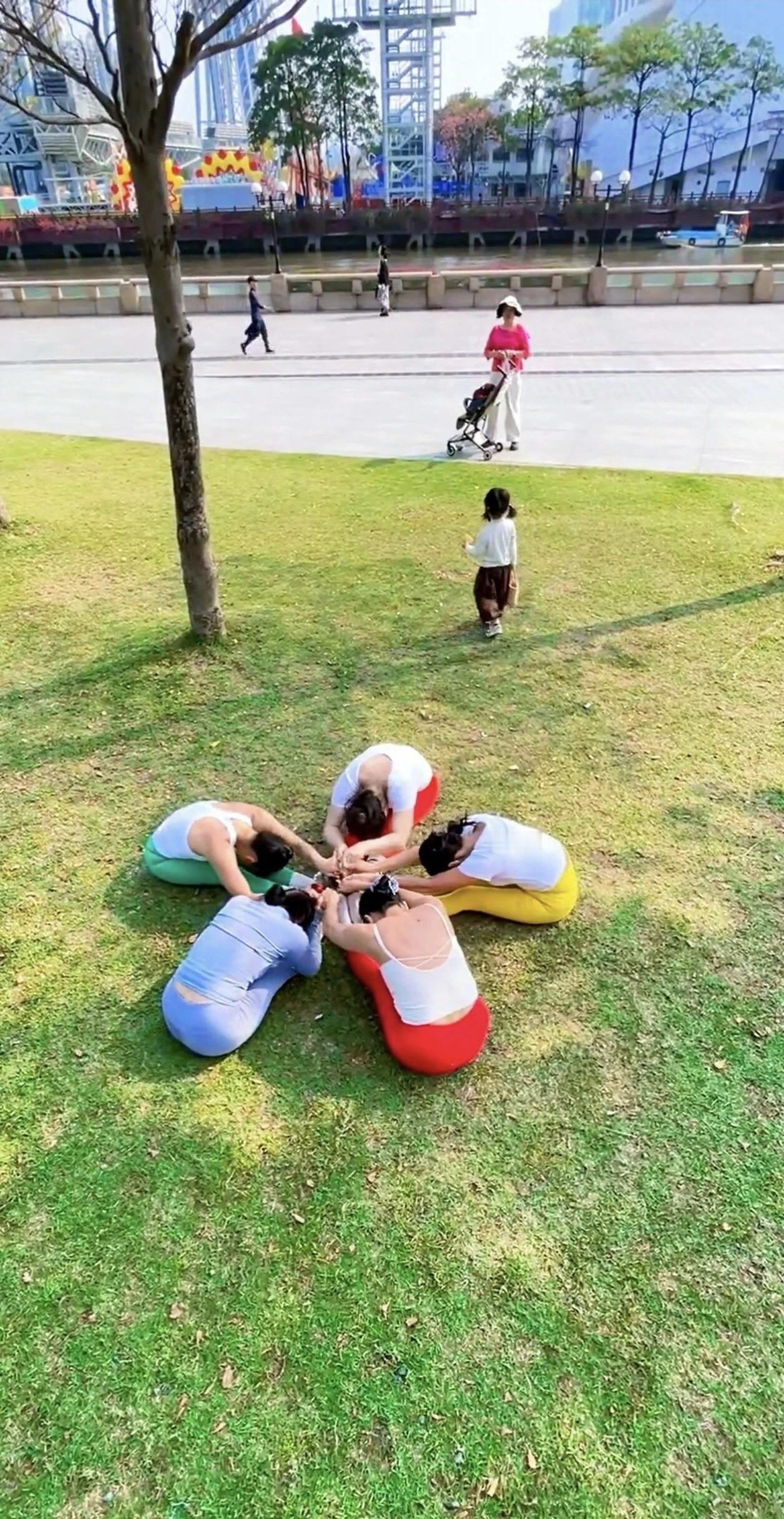 五个人在草地上摆出星形。