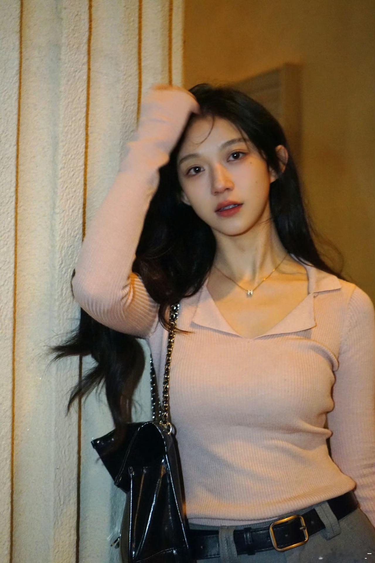 妹子靠墙摆pose，手提包配搭。
