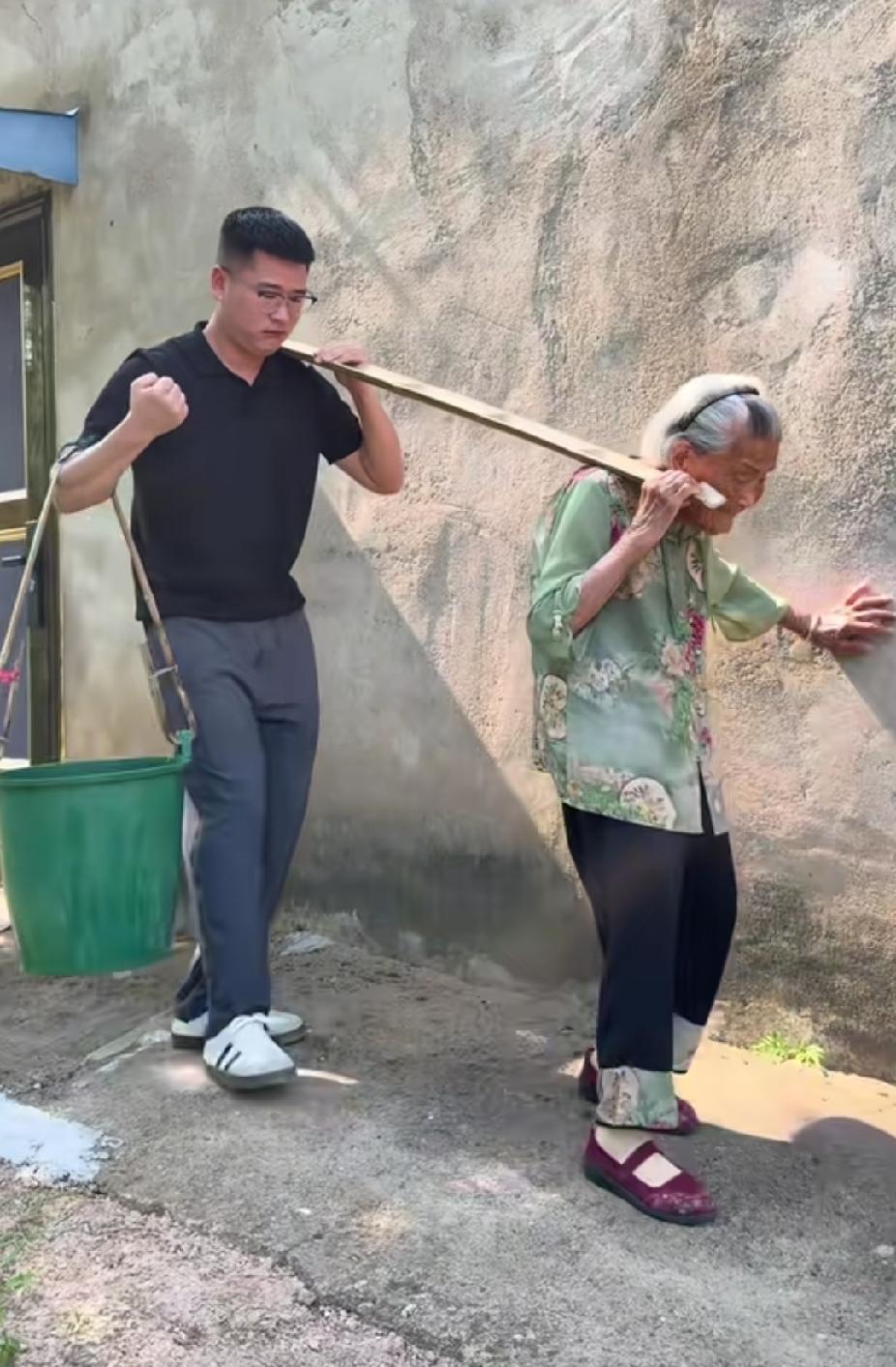 白发老人和年轻男子一起抬水，男子的一个举动，让人看着又好笑又感动暖心了。

安徽