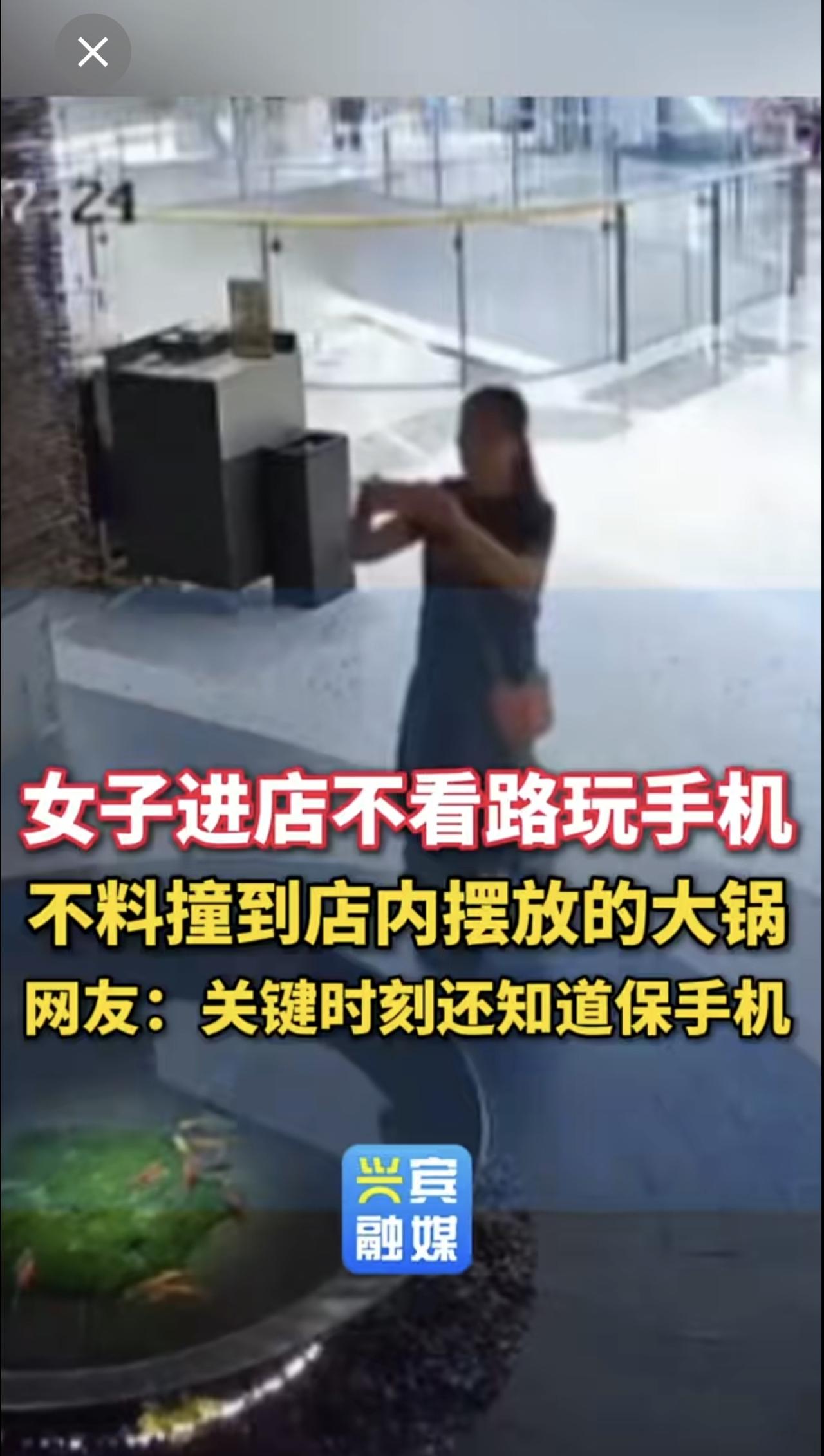 女子进店不看路玩手机，不料撞到店里内摆放的大锅。网友：关键时刻还知道保手机搞笑