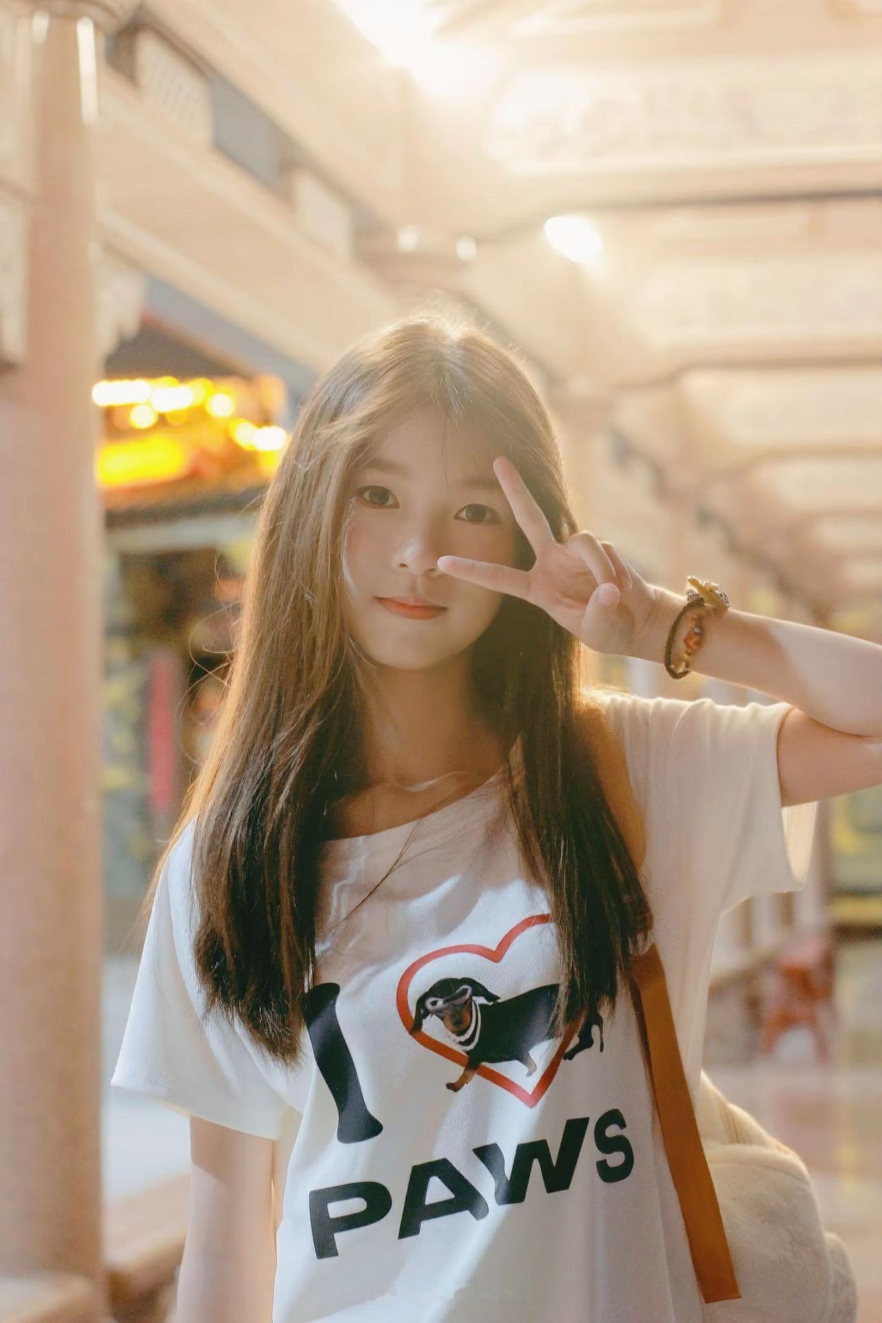 在古色古香的建筑里，她比着剪刀手，长发衬着可爱T恤，阳光一洒，元气感直接溢出屏幕