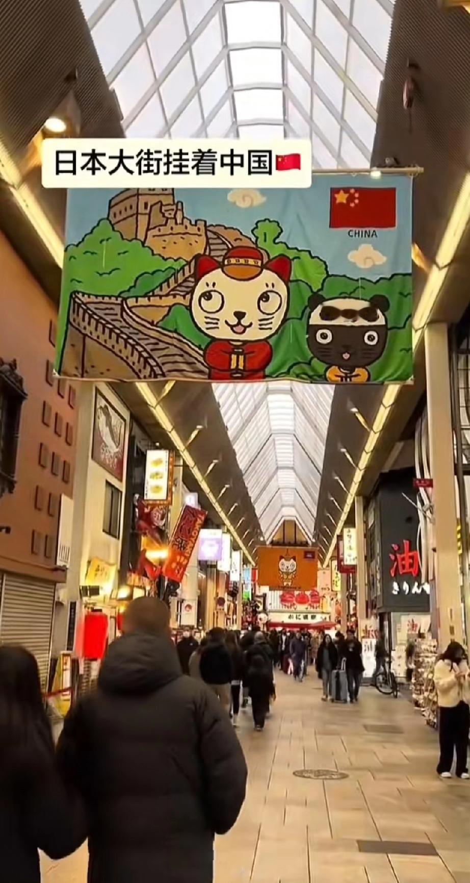 日本街头主动挂中国国旗。海报上面还有长城等中国元素