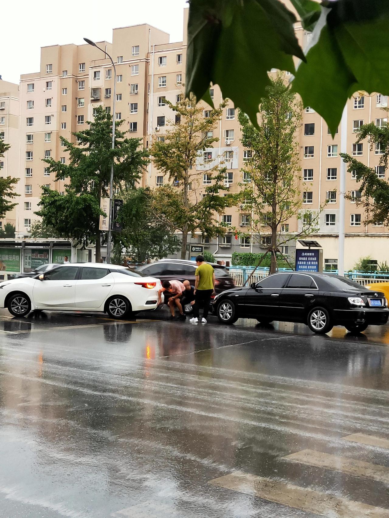 两位司机冒雨解决刮蹭