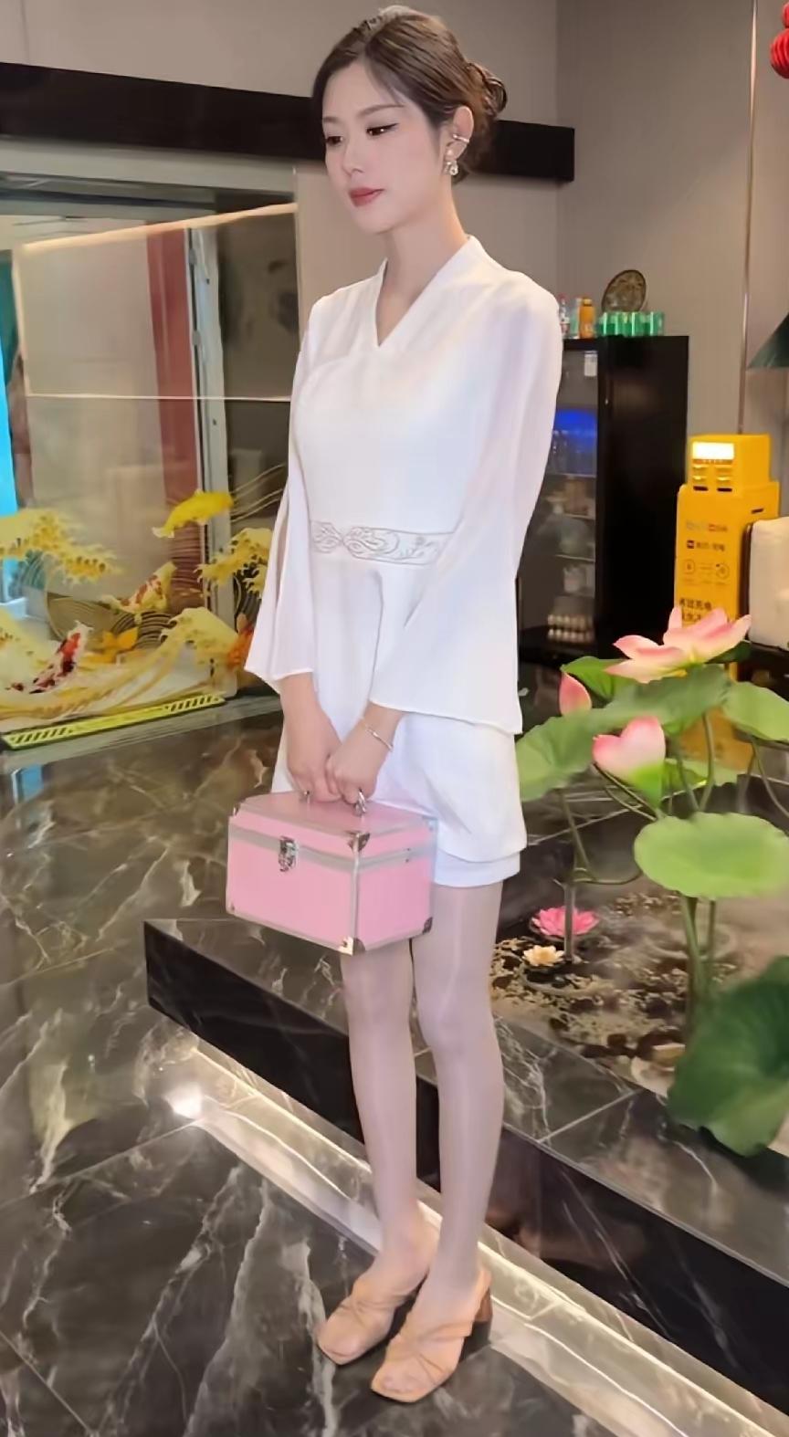 小姐姐面容娇美，楚楚动人的样子，很招人喜欢，她手里提的是什么呀，小药箱吗，知道的