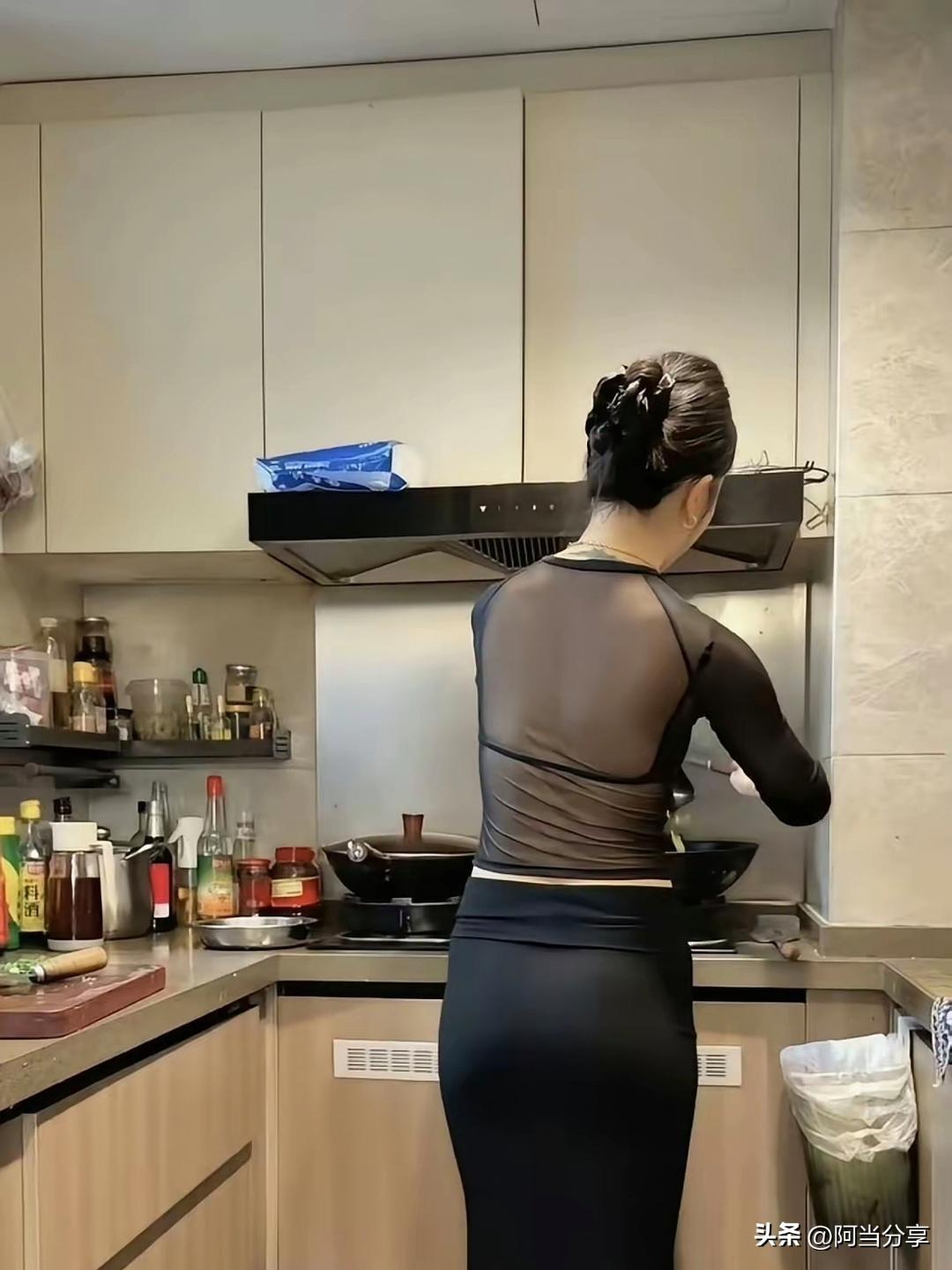 女人在厨房做饭，背对着镜头。辛苦了