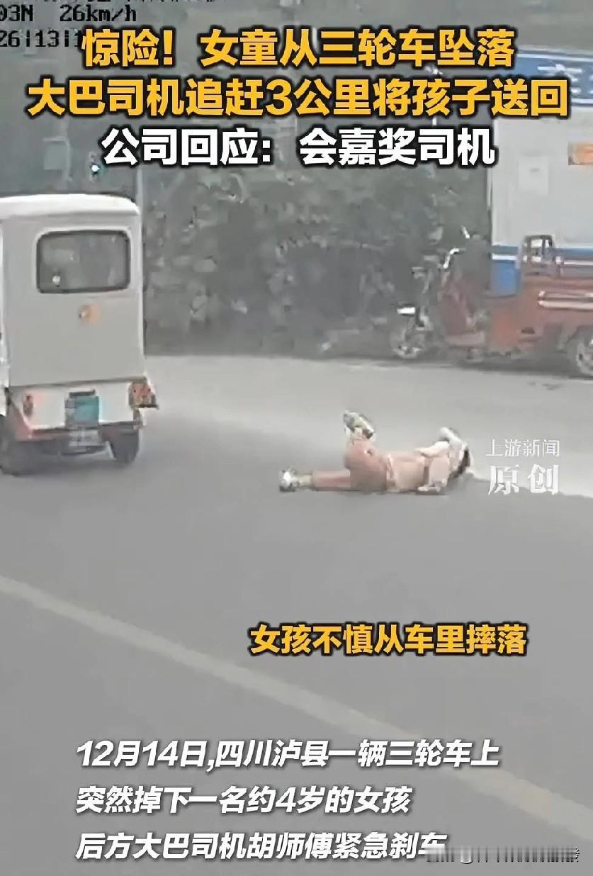 一位司机开着大巴车在路上正常行驶，拐弯时，前方一辆电动三轮车上突然掉下来一个小女