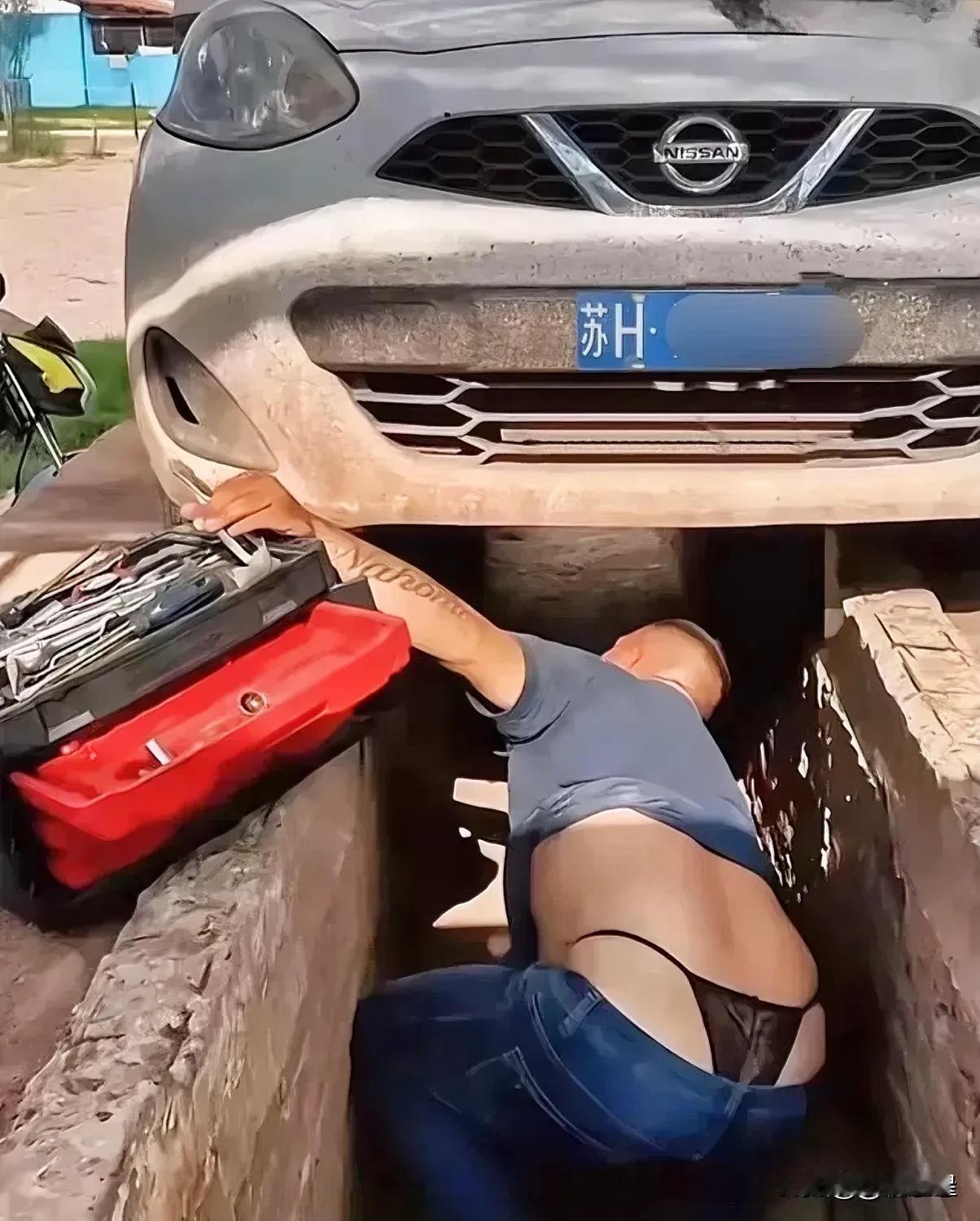 看这哥们，总觉得哪里不对！
修车师傅正为尼桑车修车，钻进汽车底盘的一瞬间觉得这哥