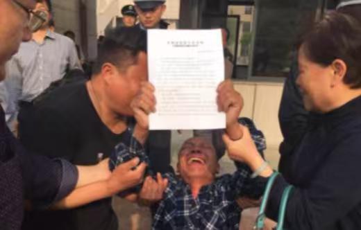 那天安徽高院门口，五个人拿着无罪判决书哭得站不稳，可赔偿申请表他们没签，就那么搁