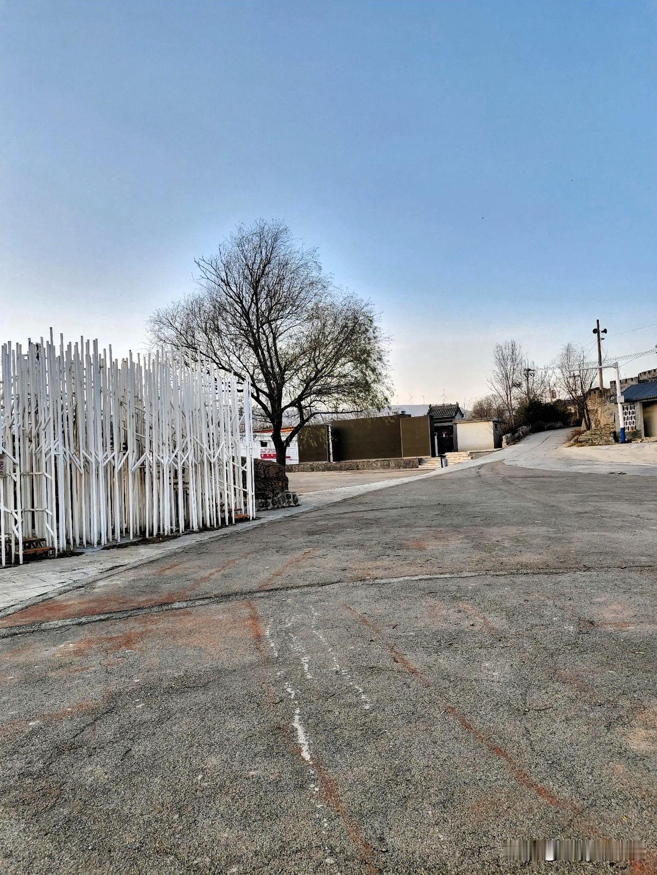 清晨的风掠过村口的路，灰扑扑的水泥地带着几分粗糙的质感，几道红痕歪歪扭扭地嵌在路