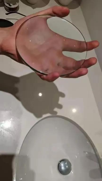 一块比手掌略大的放大镜
看起来似乎被手挡住了
但实际仍能汇聚光线成为一个光斑
仿