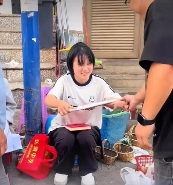 闹市口，满手泥巴的卖菌女孩正被顾客催促，邮递员硬生生挤开人群，把一个大红信封塞进