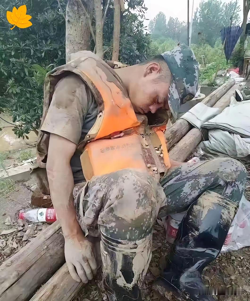 满身裹着泥浆的年轻战士，连找一处干净地方休息的力气都耗尽，只能靠着路边大树沉沉睡