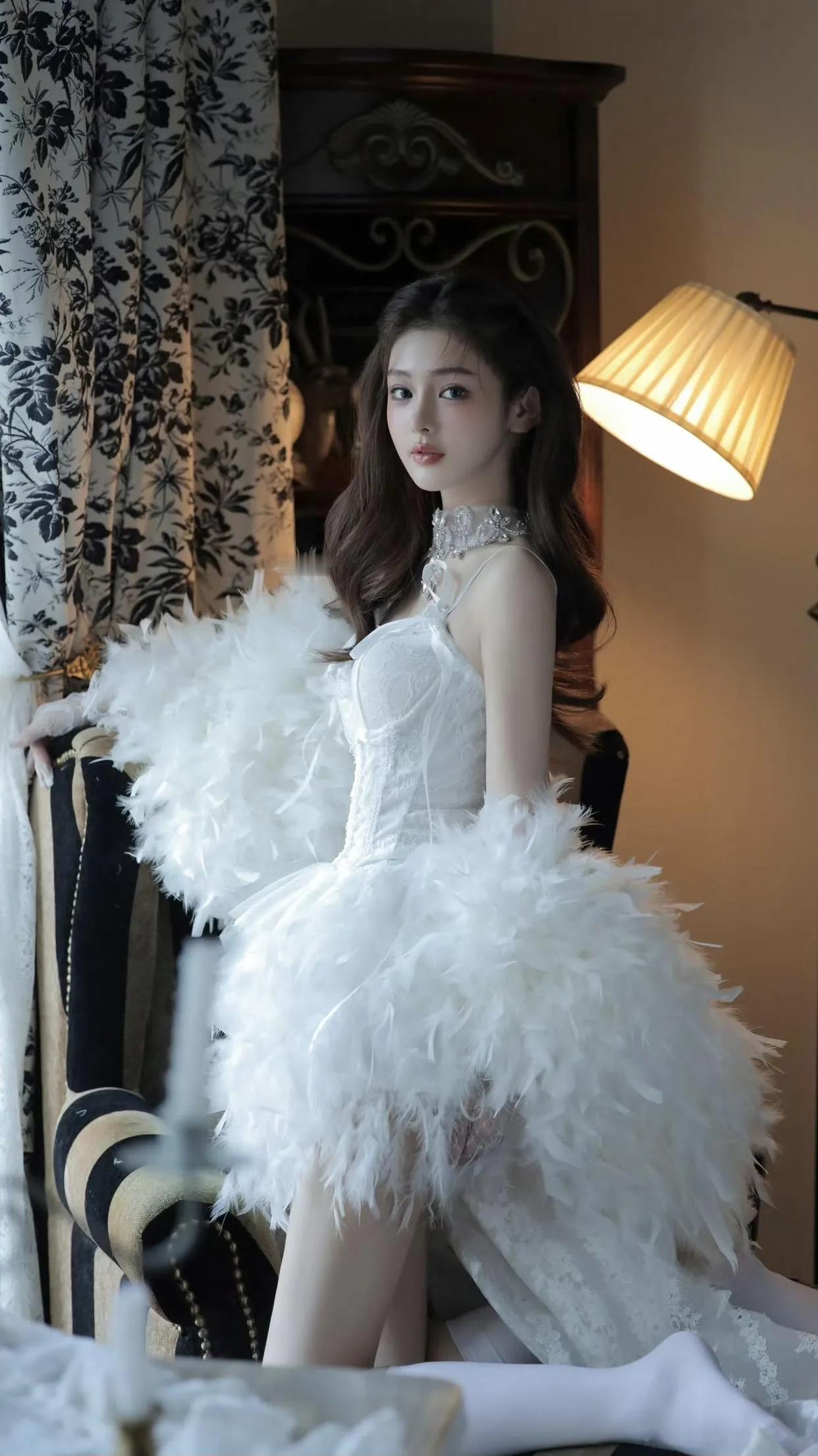 一个女孩穿着华丽的羽毛裙摆拍照片。