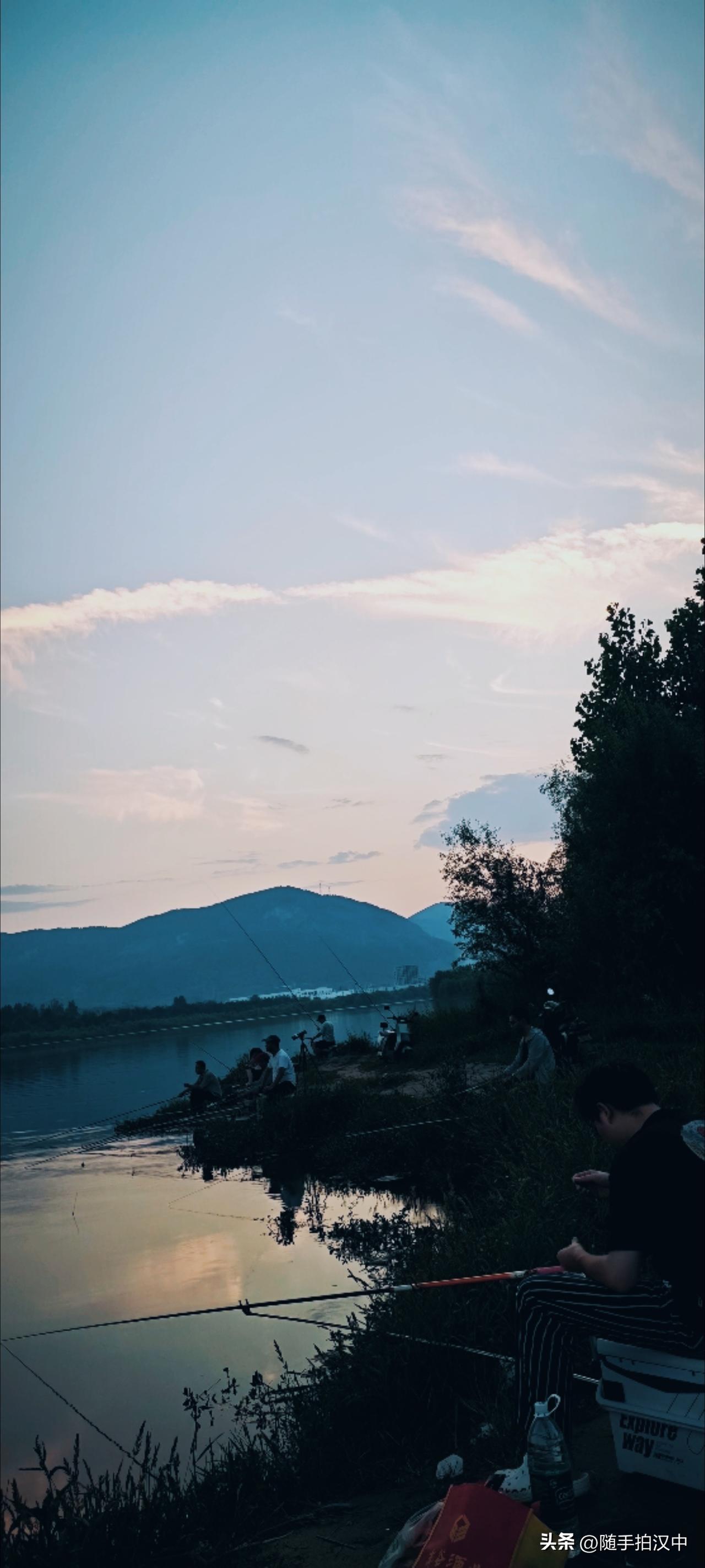 汉江岸边有排排坐的垂钓爱好者，活生生的点缀在夜幕渐起的山水间。有爱好是人生幸事，