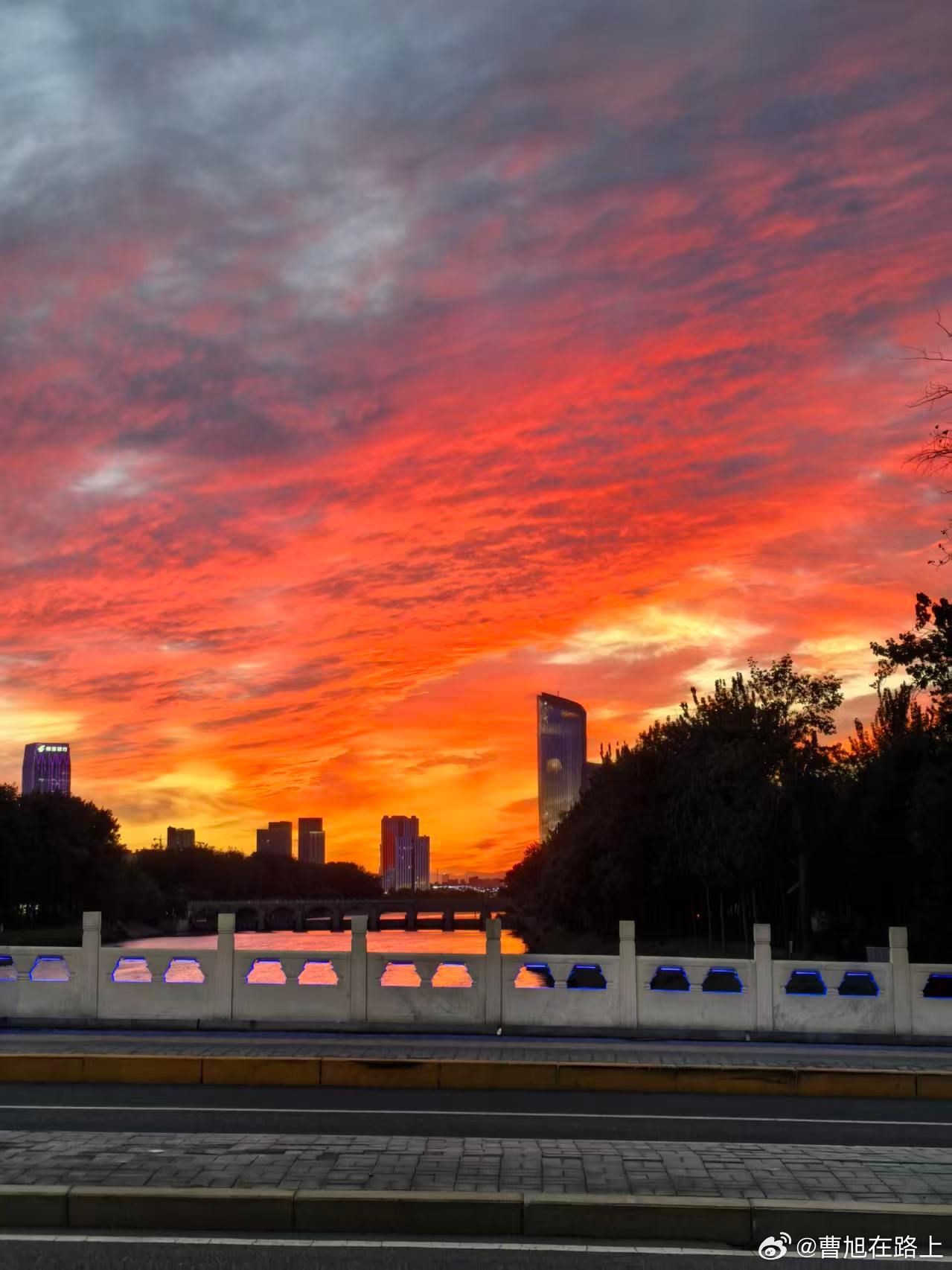 朋友不经意间拍到的天空夕阳红于烧，晴空碧胜蓝火烧云如烈焰漫天火都已经把河面给烫的