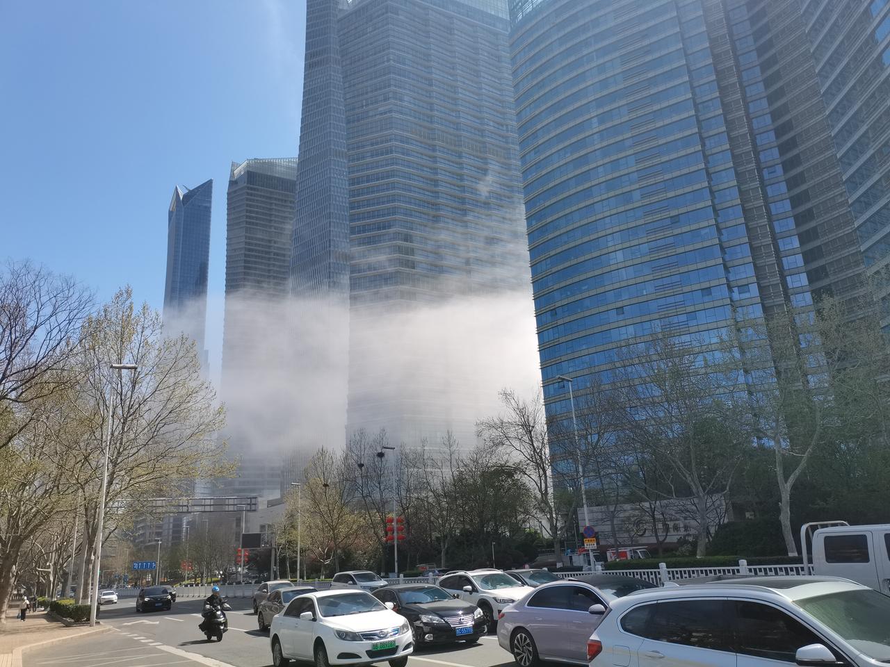 晒图笔记大赛从海面上飘来的平流雾从沿海的两座高楼大厦中间穿过，人们看见这一幕纷纷