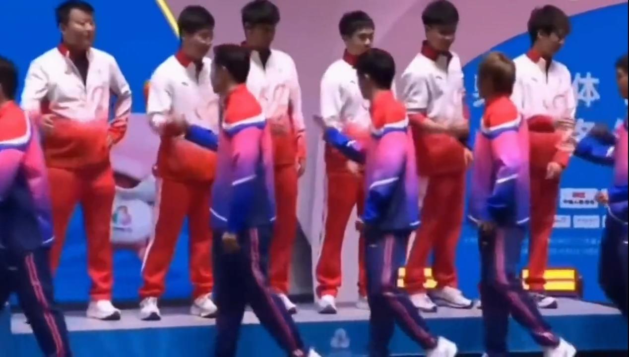 用这样的礼节领奖，真有风度。全运会乒乓球男团颁奖典礼，获得铜牌的广东队站到领奖台