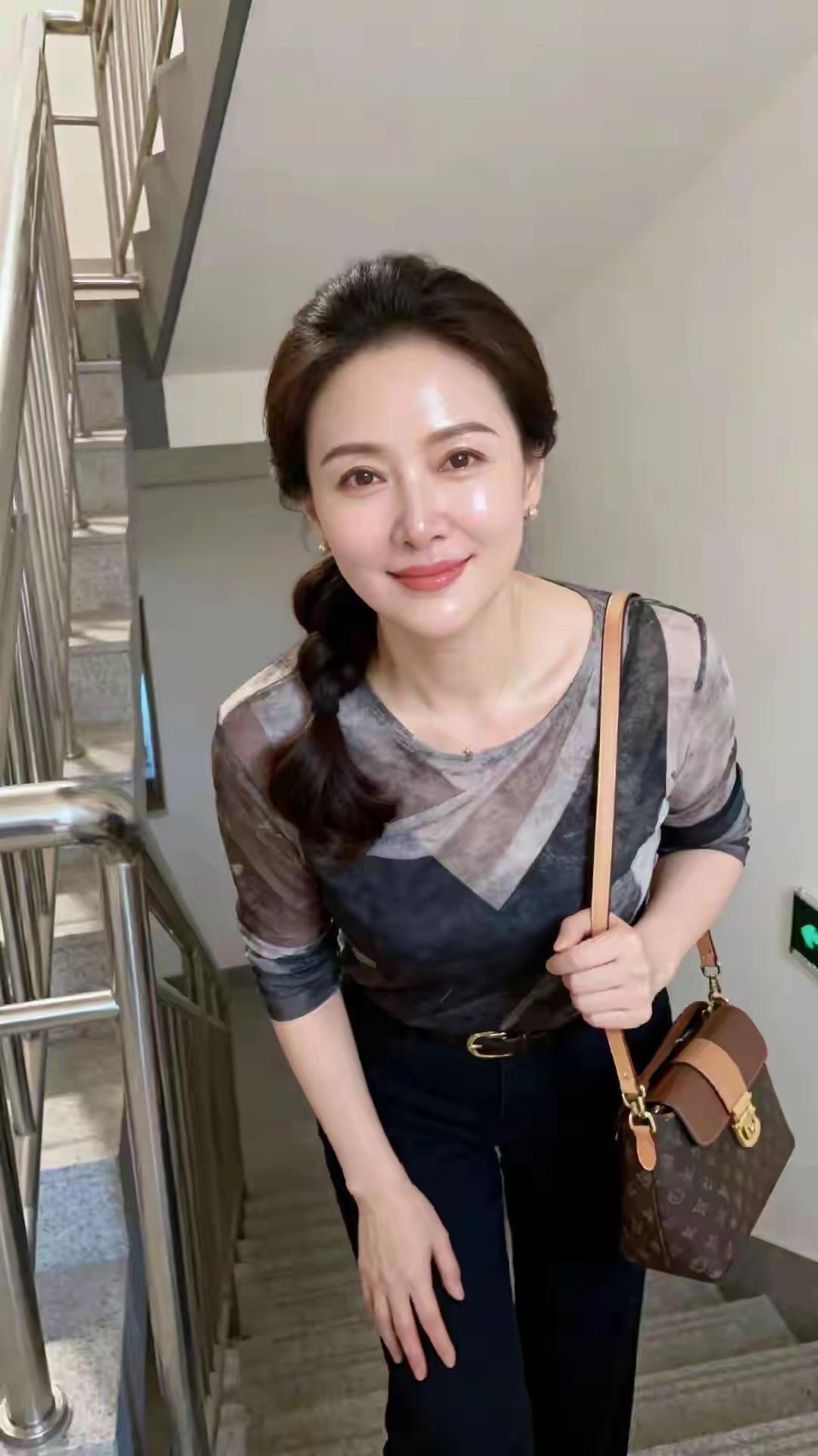 优雅气质穿搭，时尚手提包搭配，自信微笑，楼梯上的时尚女王。
