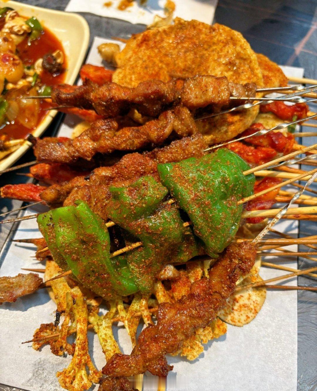 日常分享夏日夜宵标配就位！铺满一整桌烤串，青椒、五花肉、花菜烤得焦香入味，撒满辣