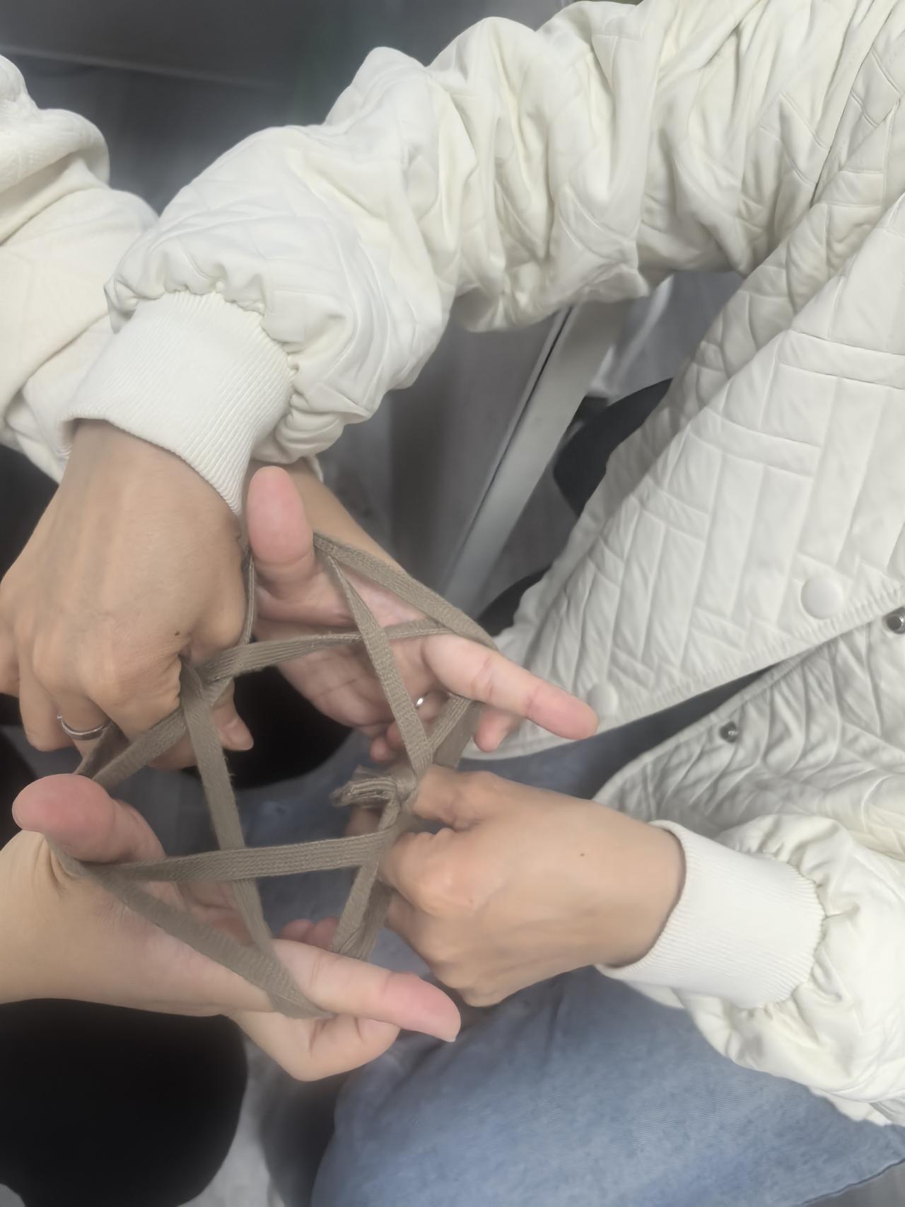 小时候的快乐真便宜，几根旧布条就能撑起整个下午。
 
攥着布条两头，手指往缝隙里