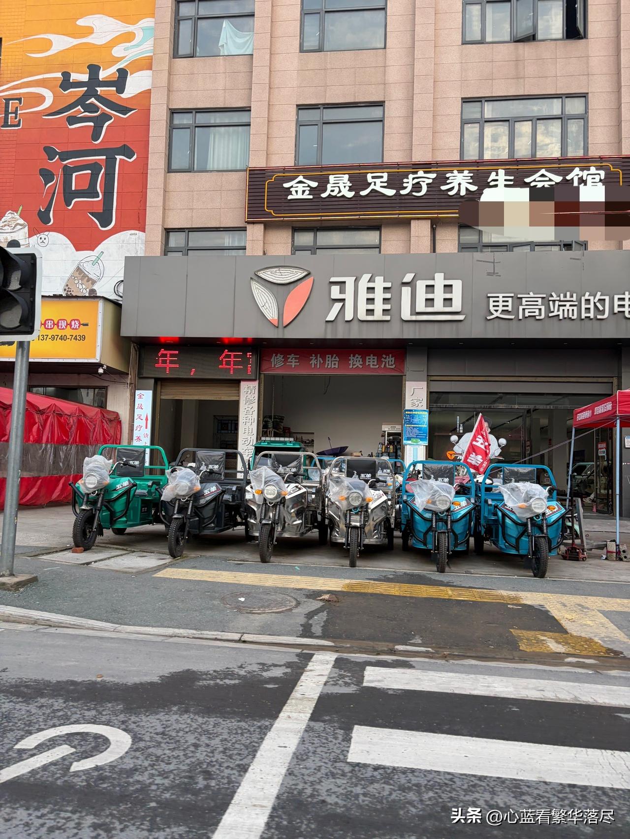 今天路过一家卖电动车的商家，看着店门前摆放整齐的多辆崭新的电动三轮车，心里不禁产