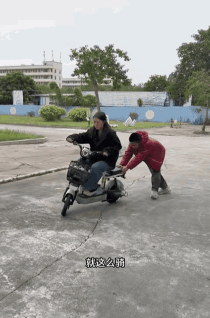 老婆学骑电动车，眼看着要撞上了，老公一脚及时止损。