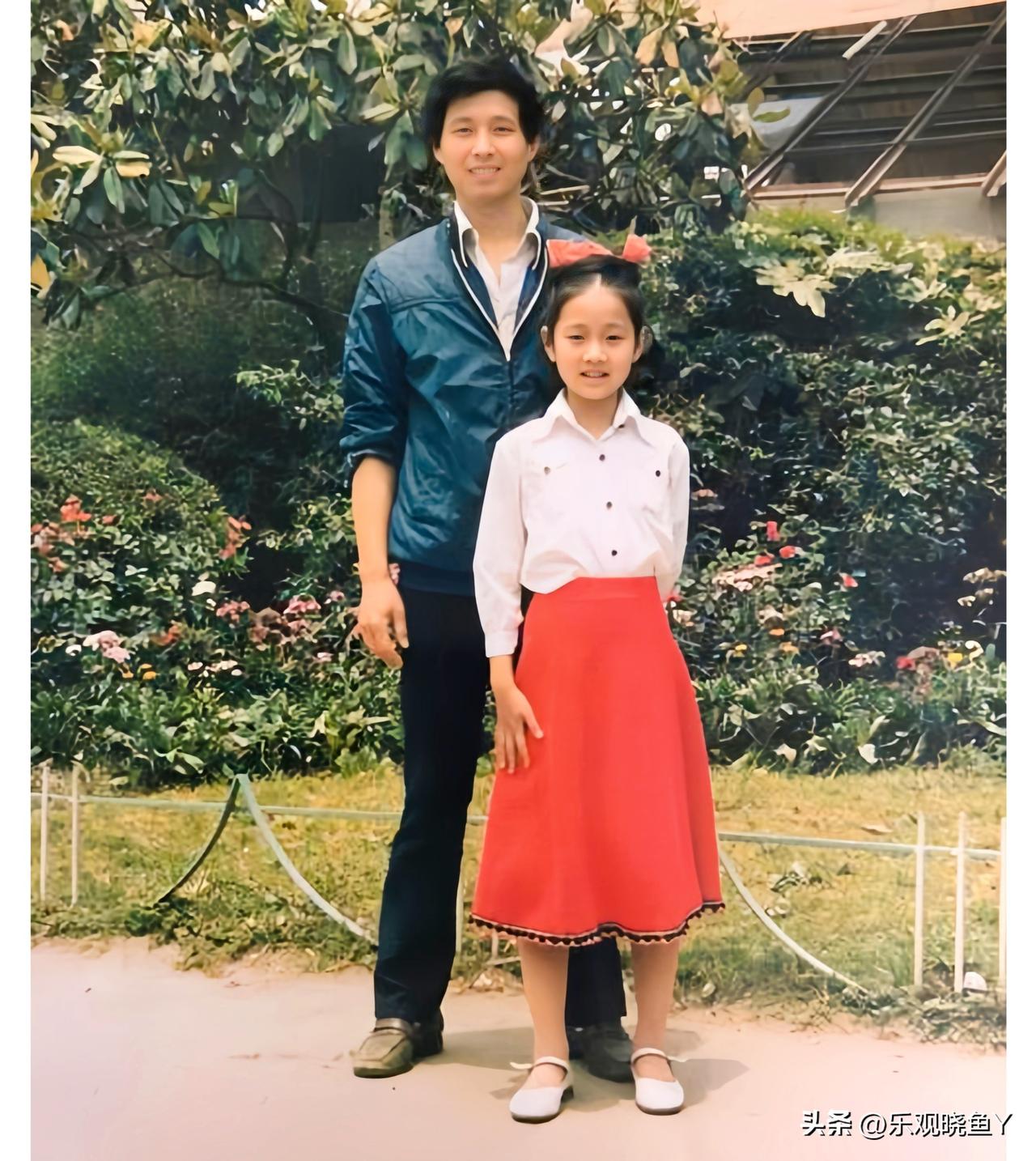 马伊琍童年老照片: 一九八五年与她父亲的合影。彼时马伊琍九岁，白衣红裙，站在父亲