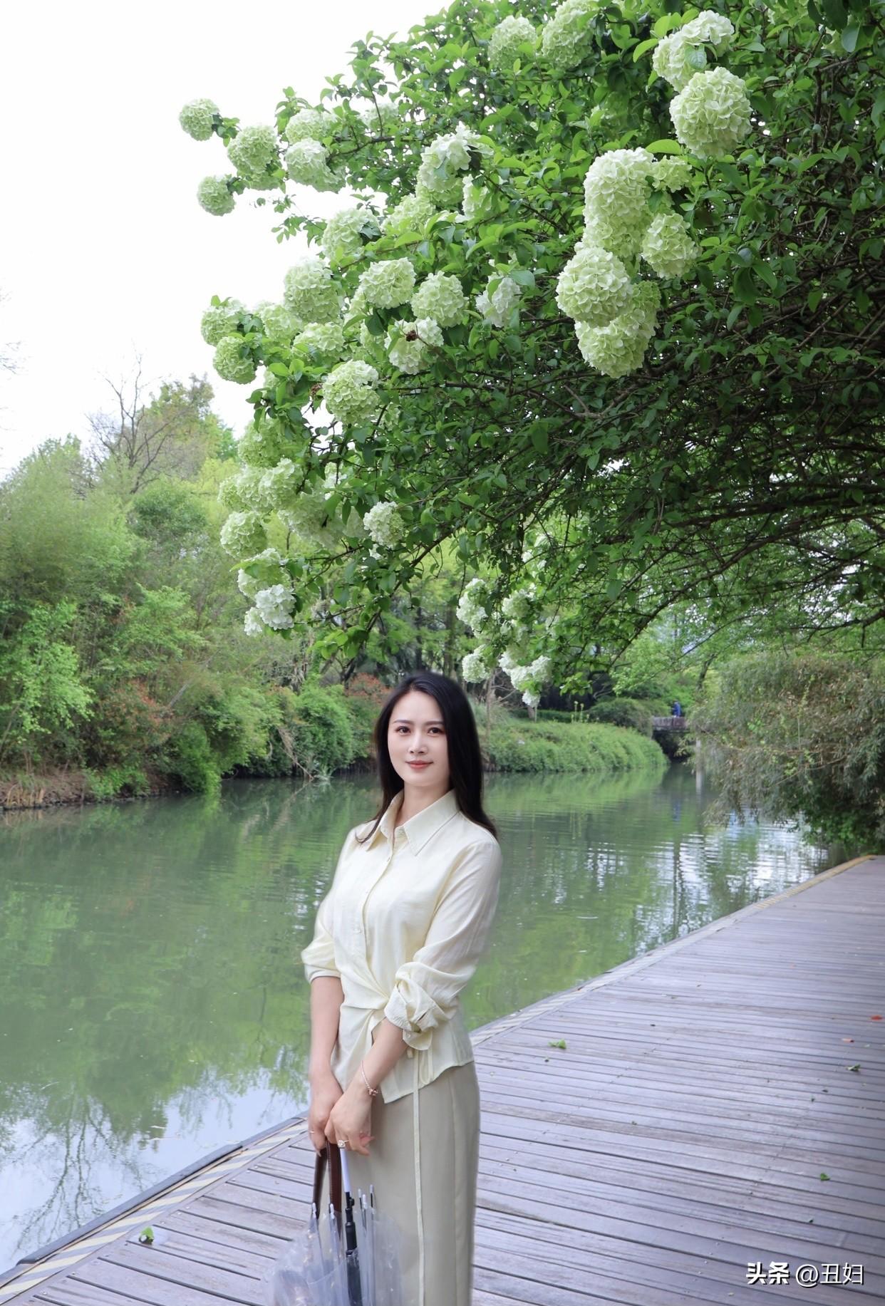 女生如何穿搭看起来时尚更有品味呢雨中漫步，撑伞漫步在绿意盎然的公园里，清新自然。