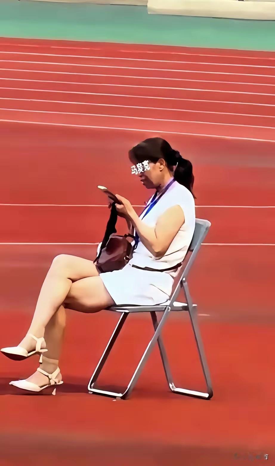 全网都在找这个甘肃陇超的女子是谁，她坐在一张椅子上，翘着二郎腿，刷着手机，脖子上