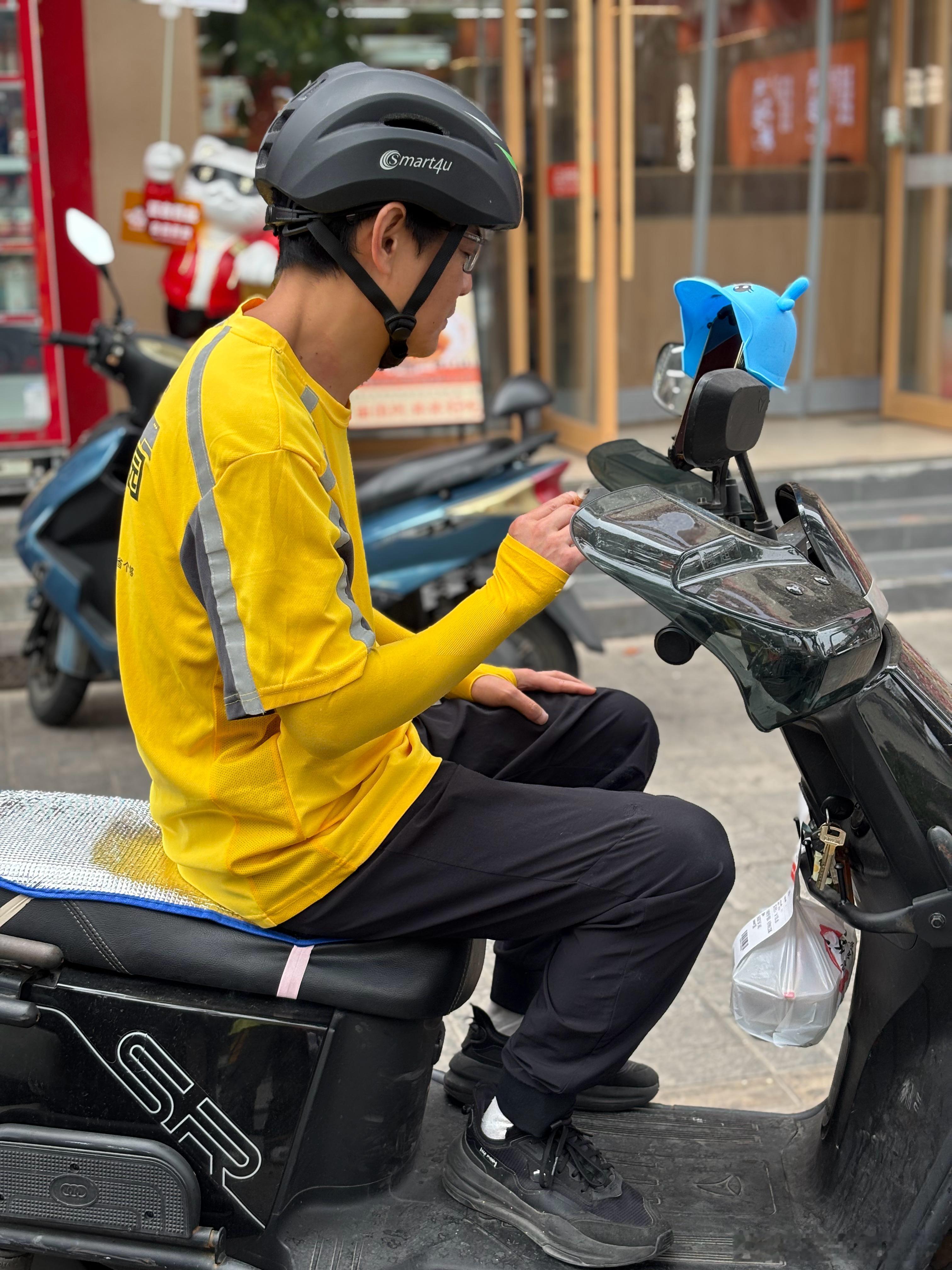 美团小哥在东北面馆门口等待取餐 