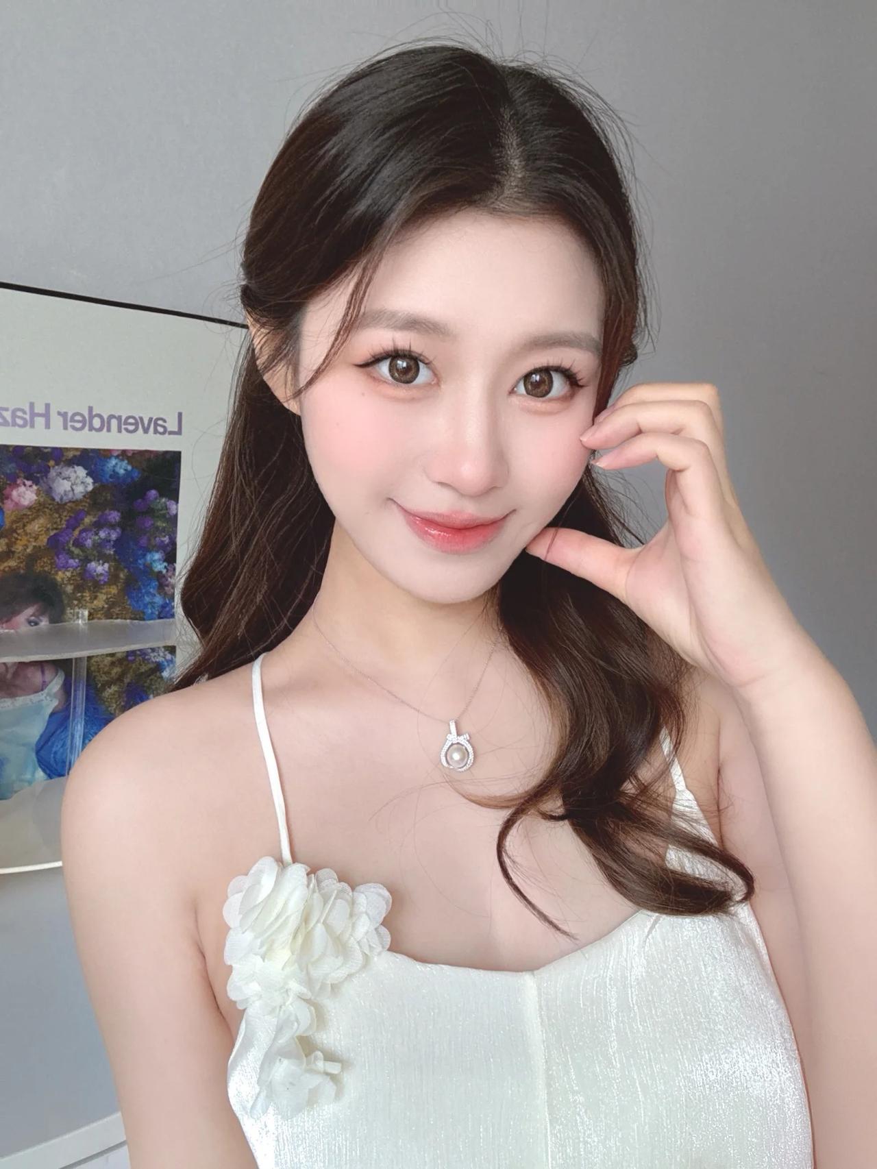 她身着一袭白色吊带裙，裙身一侧点缀着精致的立体花朵装饰，增添了几分浪漫与温柔。细