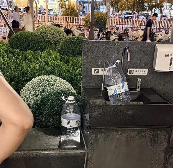 一处免费直饮水点，突然变成了“大型取水现场”，有人拿着水杯，也有人拎着大桶前往接