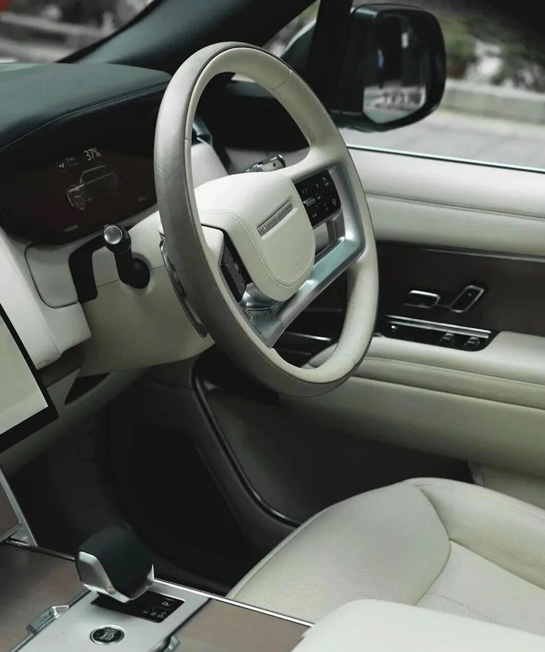 这台银白双色的路虎揽胜，是英伦豪华 SUV 的终极表达。极简的车身线条在都市街头