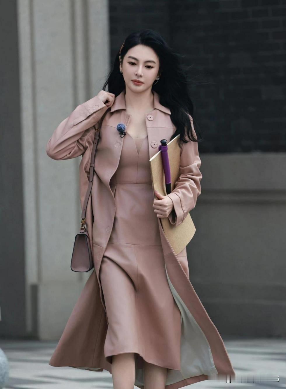 近日，演员张雨绮以一套豆沙粉风衣搭配同色系连衣裙的造型亮相，尽显优雅与自信。尽管