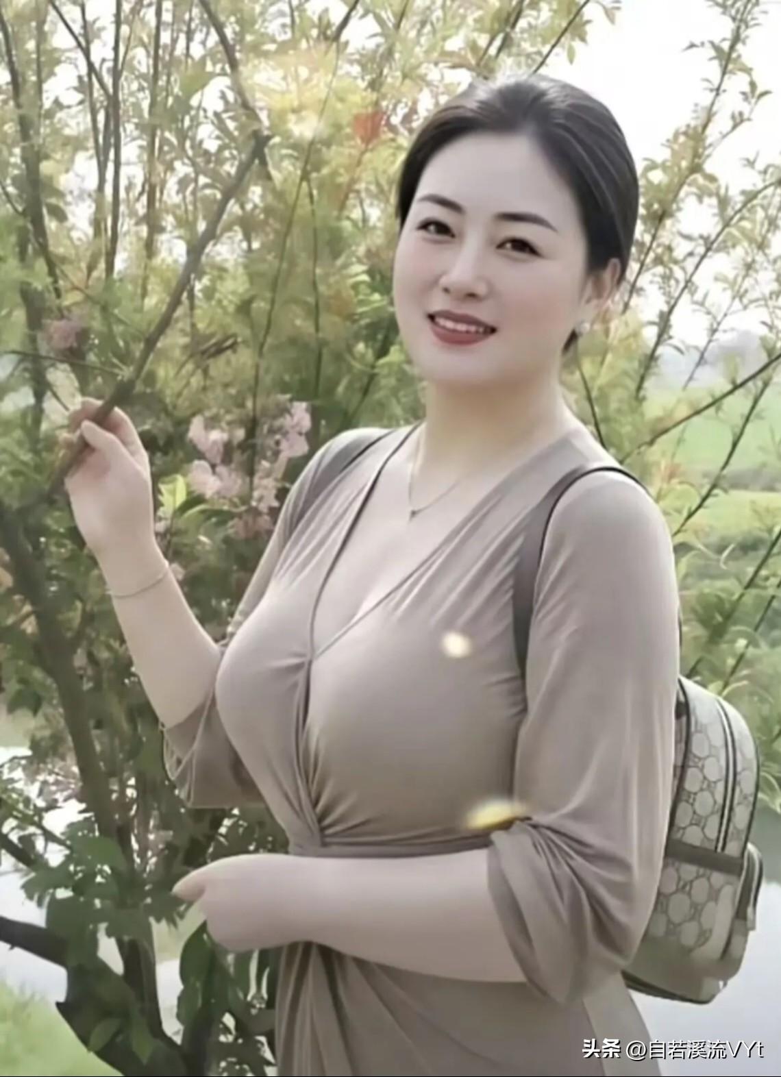 七言·郊野芳容
 
春风染翠野烟柔，一树繁花映素眸。
浅衫淡雅凝温婉，浅笑从容蕴