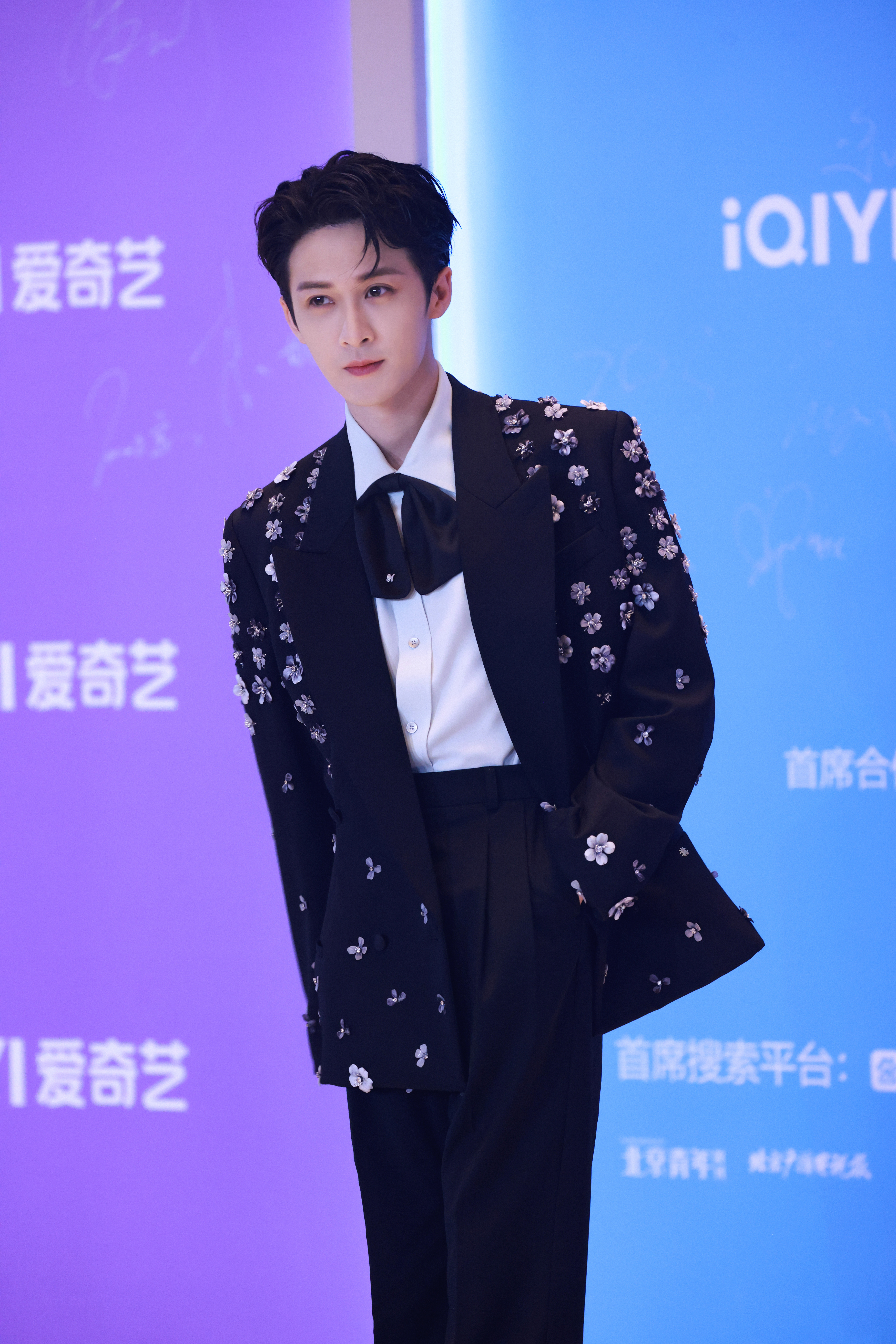 檀健次今日出席爱奇艺尖叫之夜造型，身着黑色戗驳领立体花饰西装搭配复古领结亮相红毯