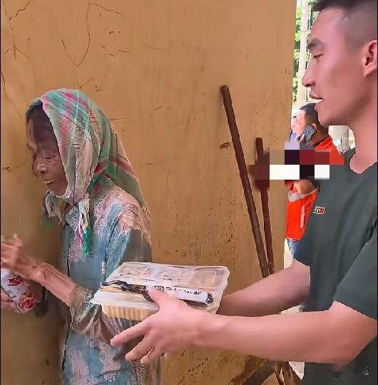 7月13日，广西，看到一阿姨准备吃罐装八宝粥，一名武警战士硬是把自己的热饭塞给阿
