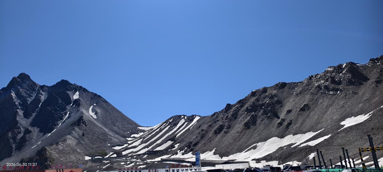 翻越哈希勒根达坂时，近处的雪山如一幅天然画卷铺展在眼前——皑皑白雪覆盖着深灰色的