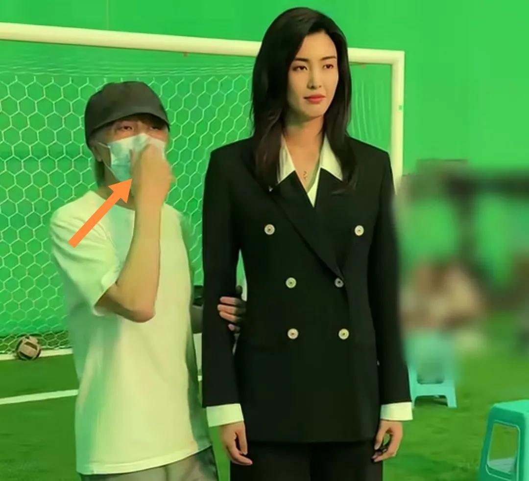 周星驰戴口罩和一足球女生合影。