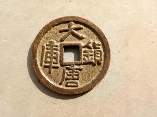 长安西市的钱铺前，一个老汉攥着刚到手的"乾元重宝"，手在抖。昨天他还能用十枚开元