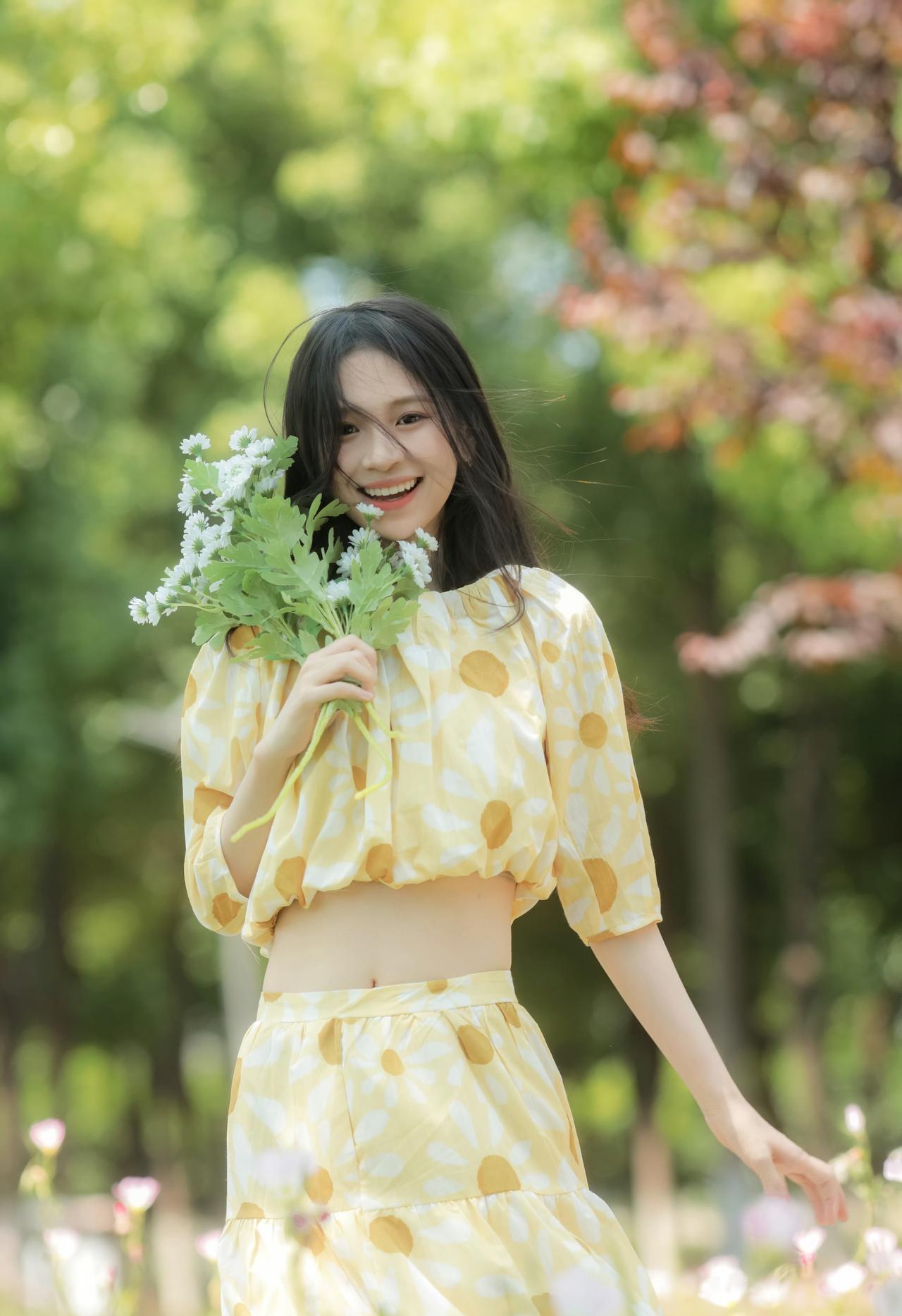 黄裙裹着夏的光斑，花束顶在发间晃成甜丝丝的风，是草地里漫出来的元气。