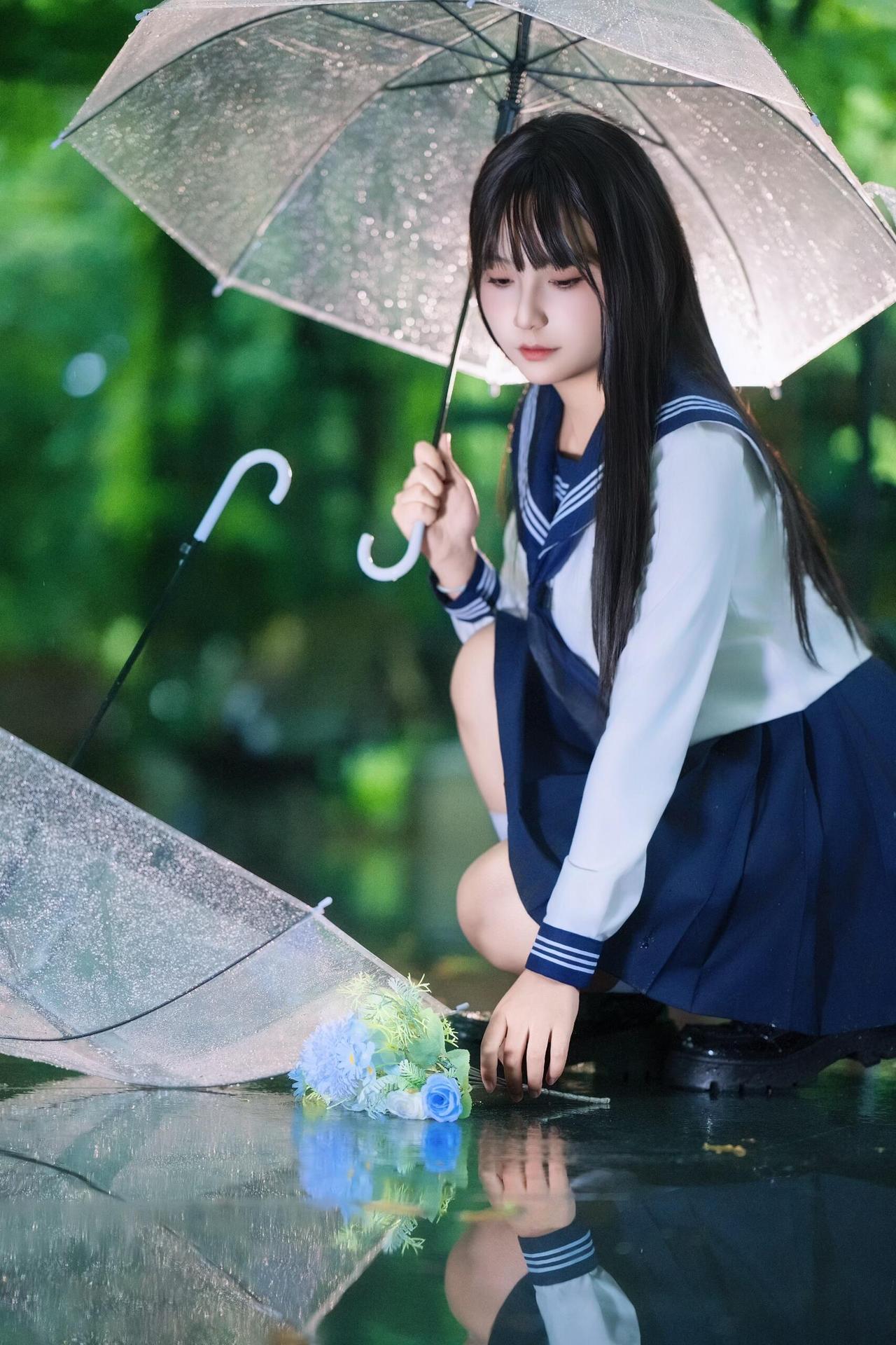 坐在长椅上的少女，把透明伞变成了雨天里的“保护壳”。画面里的元素很日常——长椅、