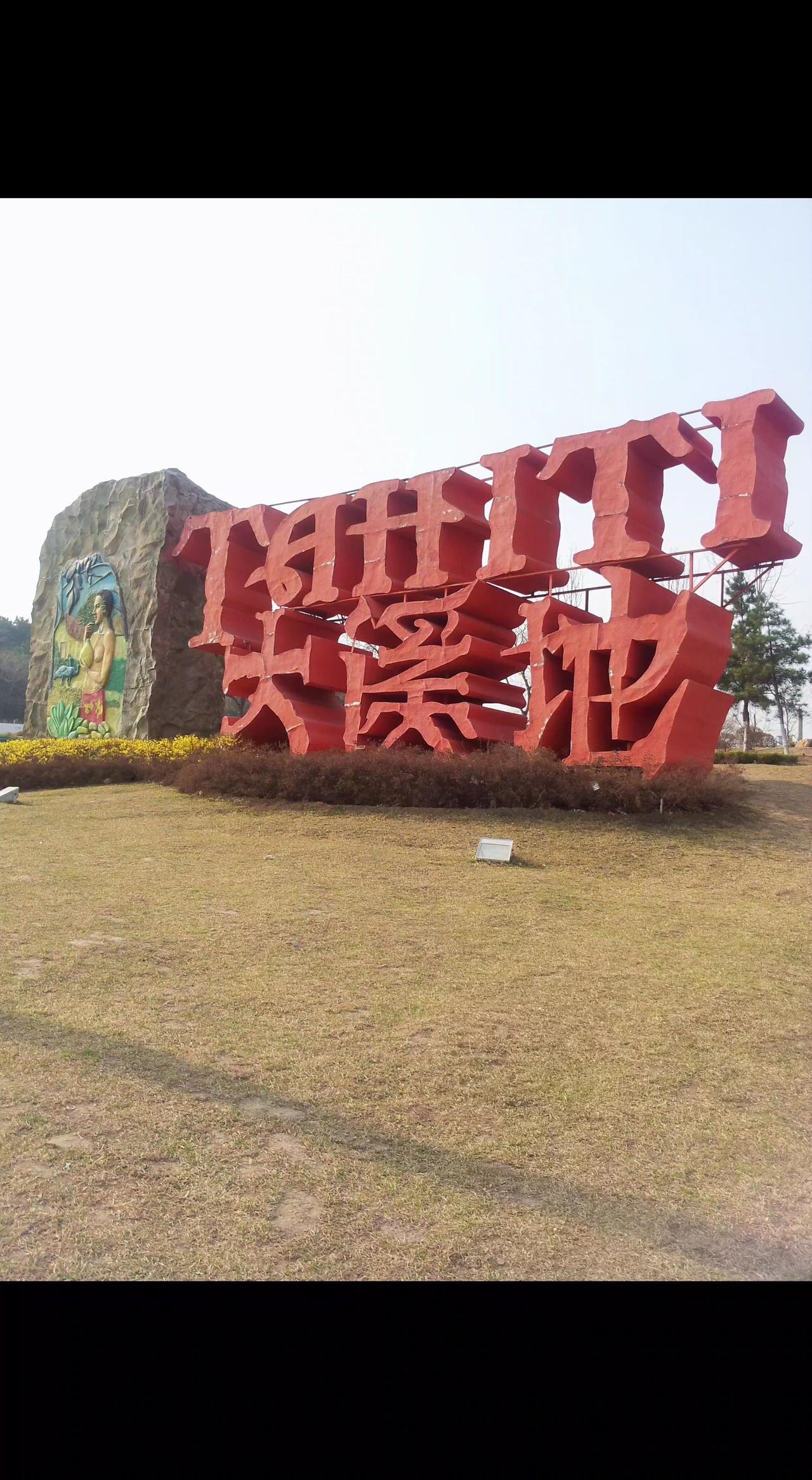 🔥红漆大字刺破草地，像团燃烧的梦🌿。石上彩绘藏着故事，等你来读这片天地的诗
