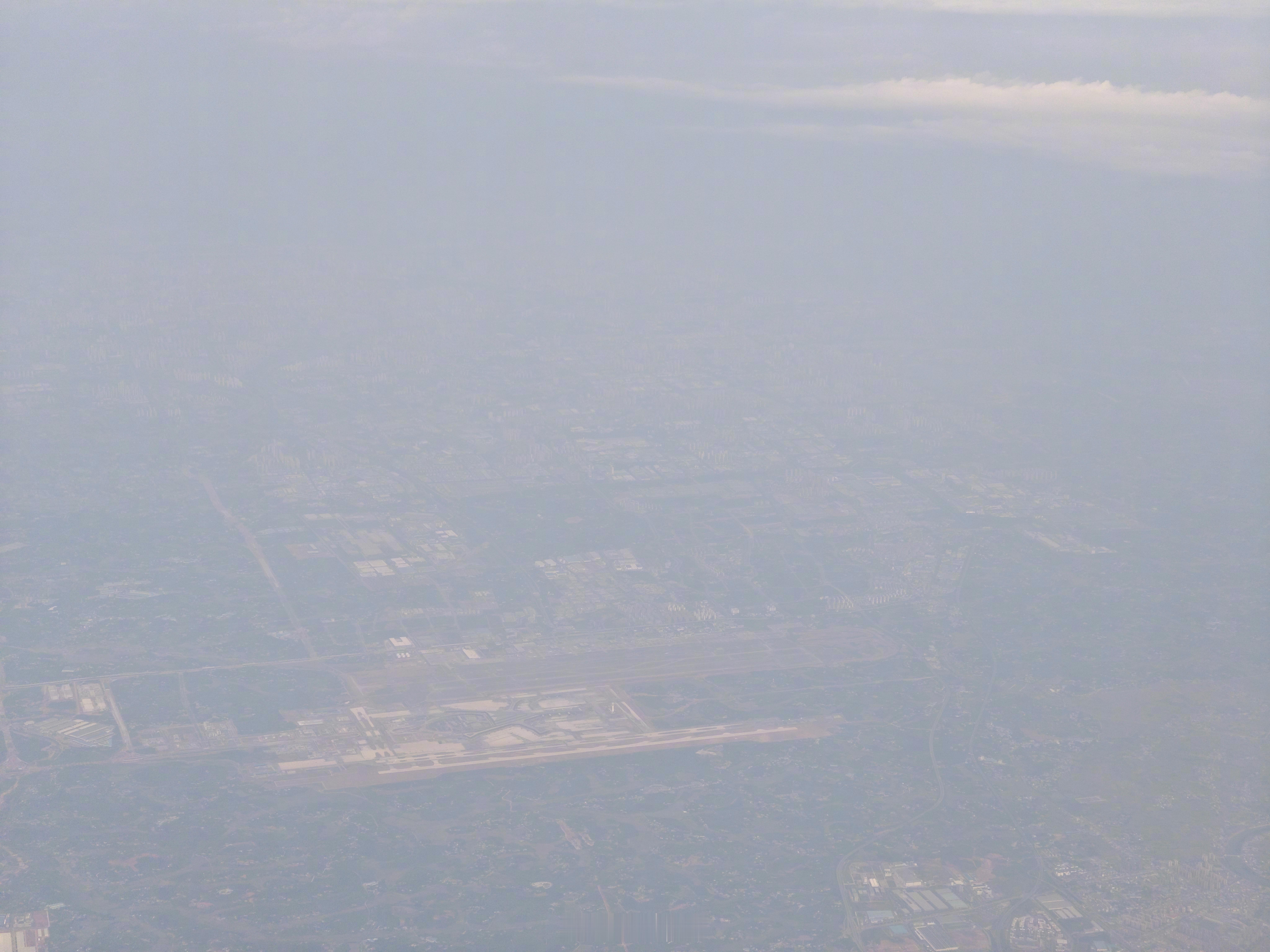 远远的空中路过一下长沙，虽然天气不好，但还是能隐约看出黄瓜机场T3和三跑完成度挺