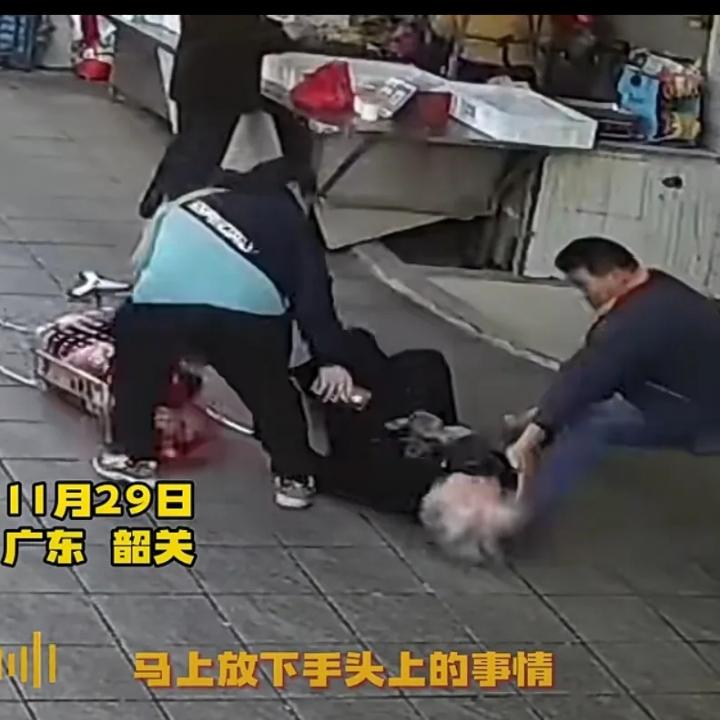 广东韶关，一白发苍苍的老人拉着推车在市场门口路过，突然一个没站稳仰面朝天，万万没