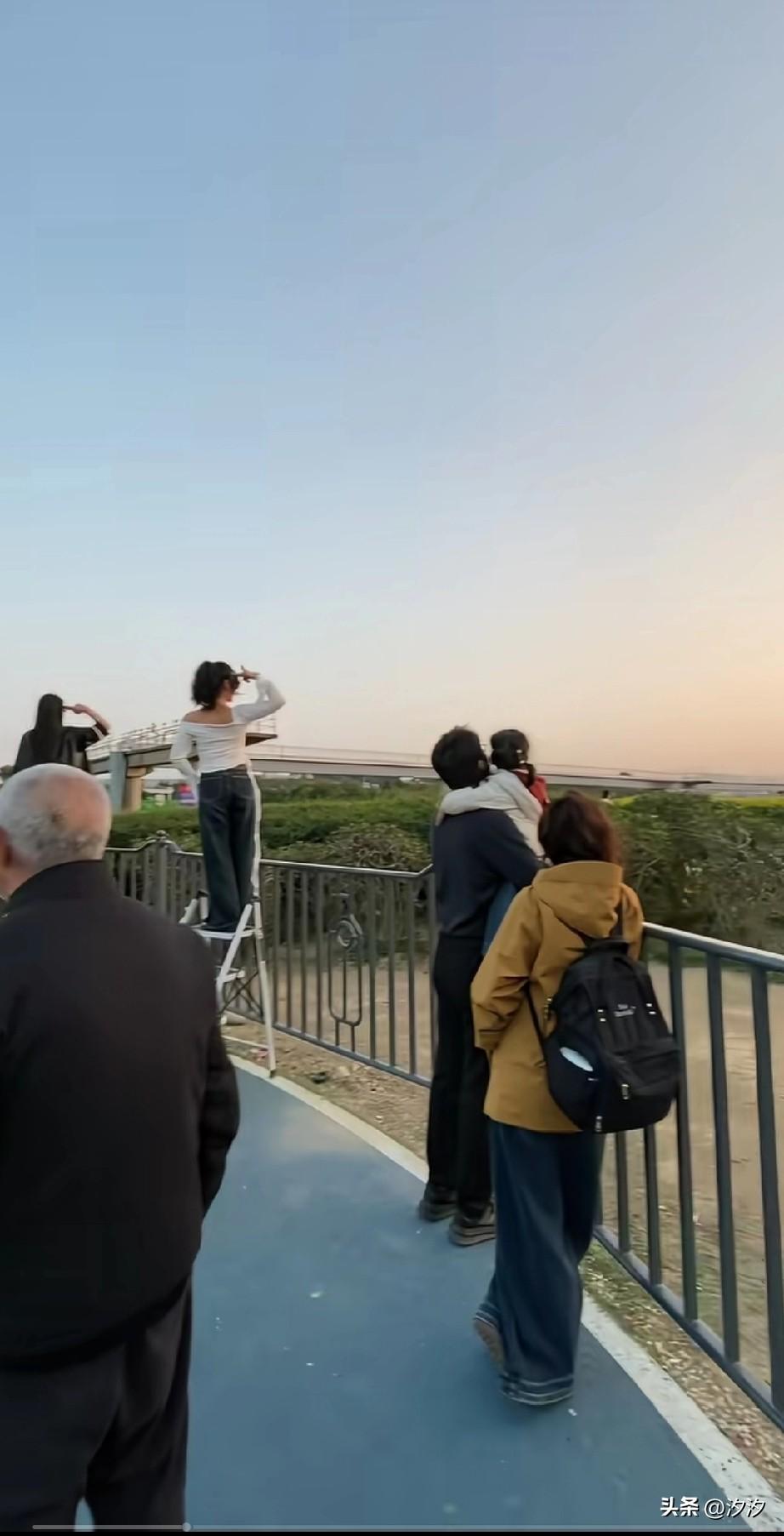 没有想到绝美照片还能批量生产，
女生们想拍好的照片，
居然集体站在梯子上，
等着