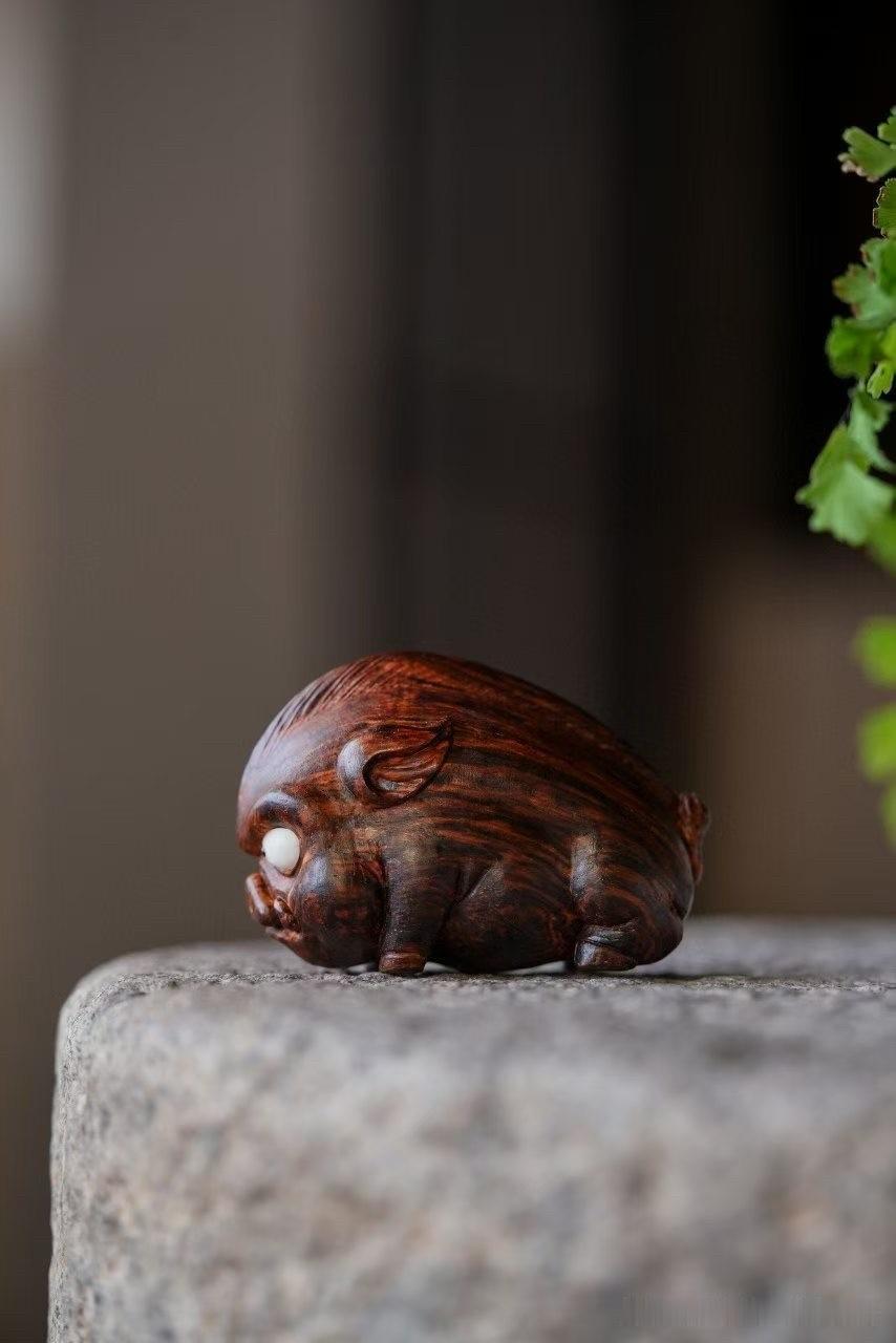 海南黄花梨｜野猪

海黄木纹翻涌如火，顺势雕出一只伏地蓄力的小野猪。身形浑圆敦厚