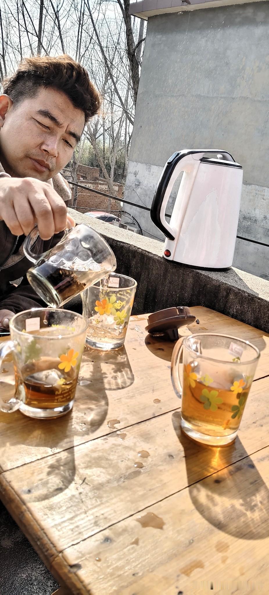 今天天气真好，阳光晒在身上暖乎乎的。我家那位搬了张桌子在阳台，正慢悠悠地给大家倒