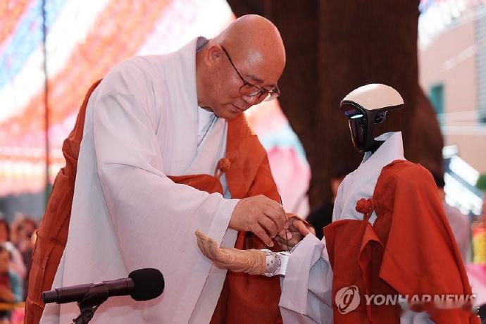 【韩国寺庙举行机器人受戒仪式】近日，韩国首尔曹溪寺大雄殿前一台人形机器人G1被赐